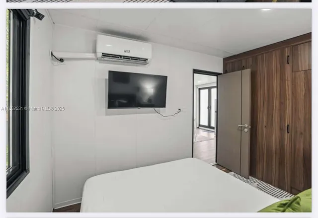 a bedroom with a bed and a flat screen tv