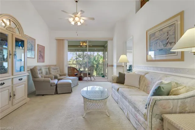 a living room with furniture chandelier and a large window