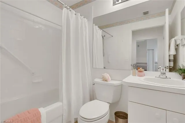 a bathroom with a sink a toilet and shower curtain