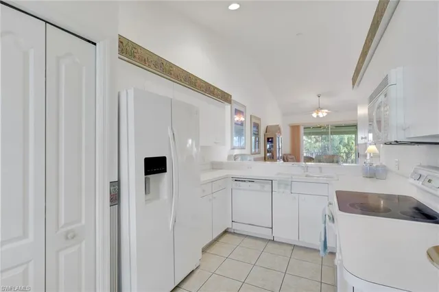 a kitchen with white cabinets and white appliances