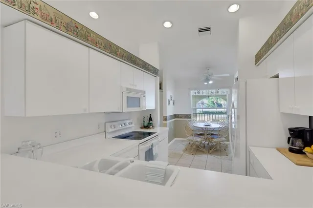 a kitchen with stainless steel appliances a sink a stove and white cabinets