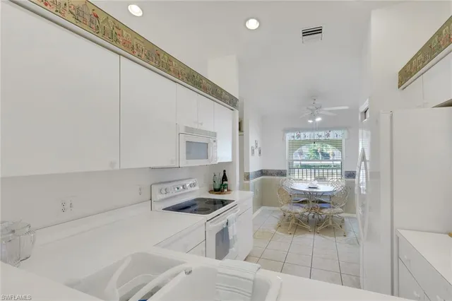 a kitchen with stainless steel appliances a stove a sink and white cabinets
