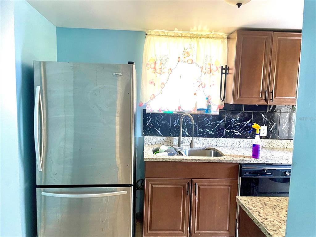 307 South Hiawassee Road Orlando, FL 32835 - Photo 9 of 13 a kitchen with stainless steel appliances granite countertop a refrigerator and a sink