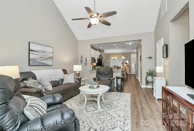 a living room with furniture a chandelier and a flat screen tv