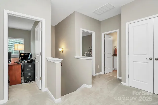 hallway with wooden floor and cabinets