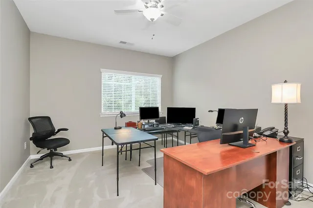 a view of a workspace with furniture and a window