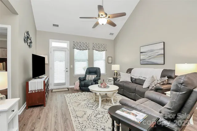 a living room with furniture a flat screen tv and a large window