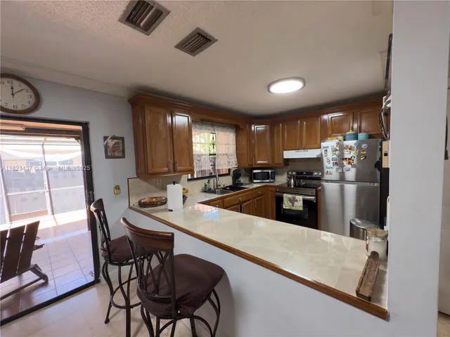 a kitchen with stainless steel appliances granite countertop a refrigerator and a sink