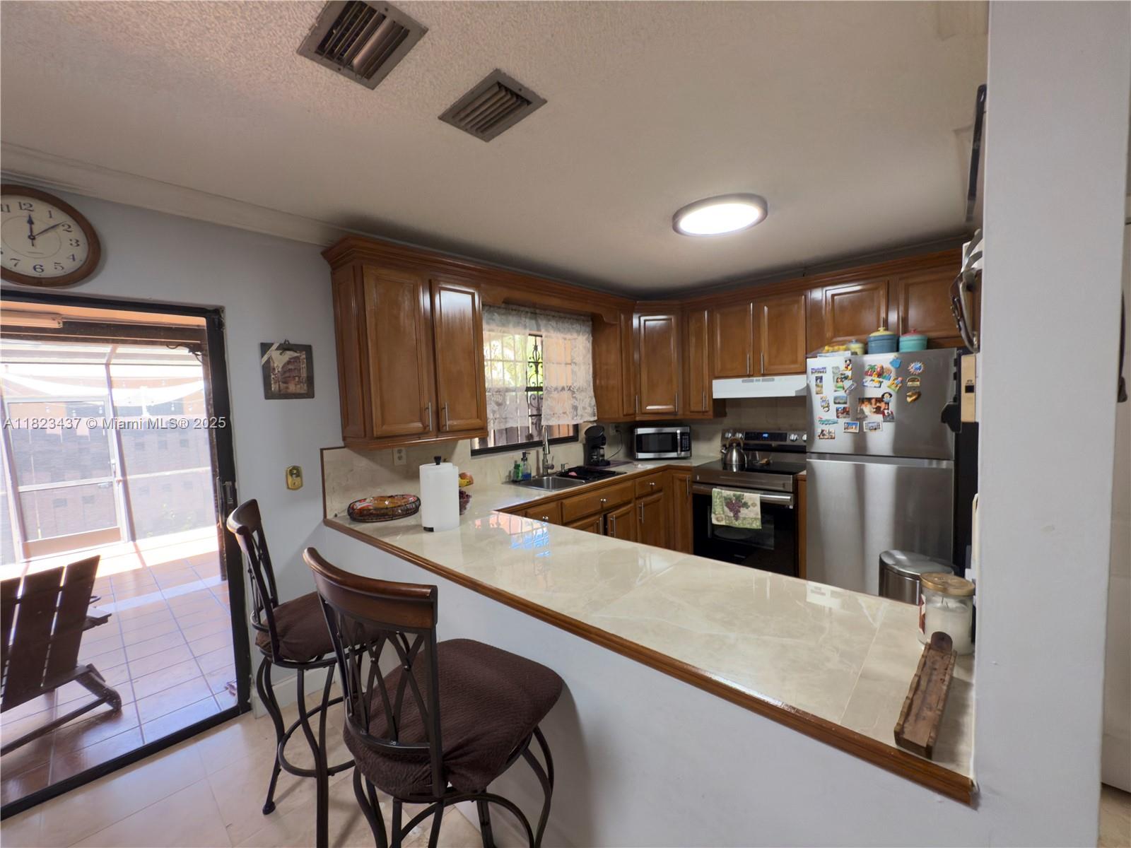 1651 Southwest 120th Avenue Pembroke Pines, FL 33025 - Photo 13 of 34 a large kitchen with a table and chairs