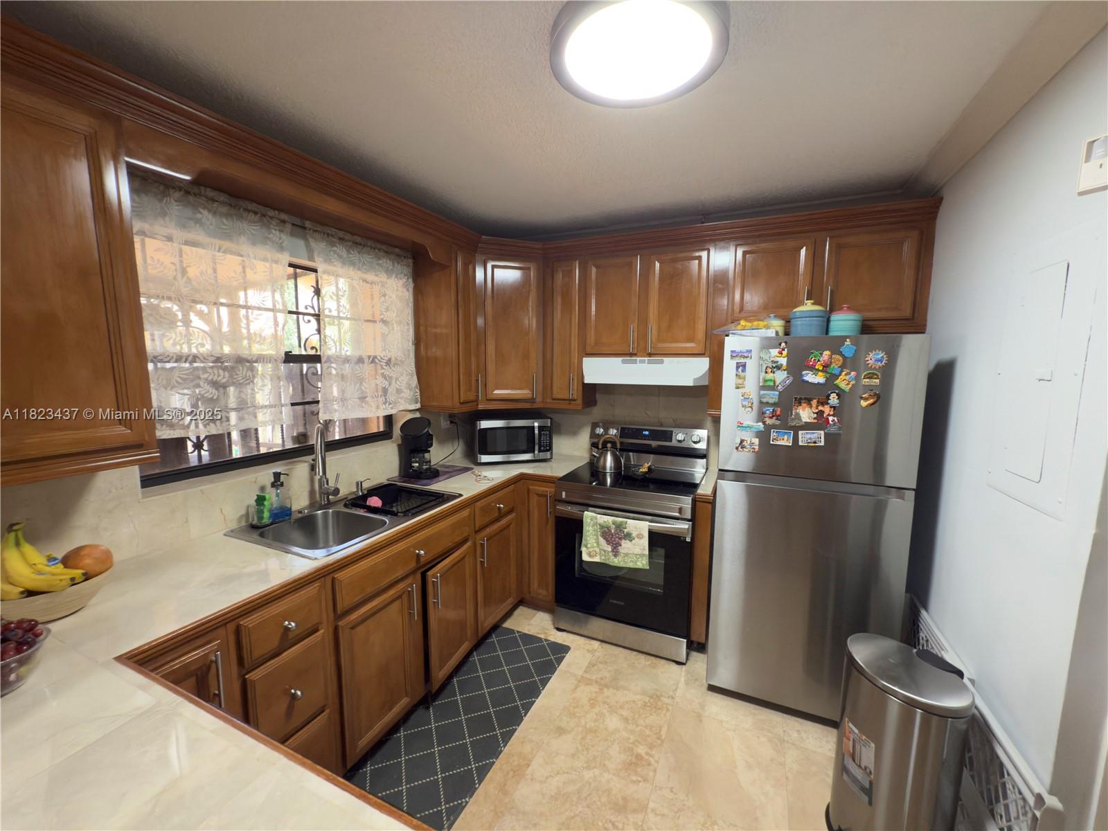 1651 Southwest 120th Avenue Pembroke Pines, FL 33025 - Photo 14 of 34 a kitchen with stainless steel appliances granite countertop a refrigerator and a sink