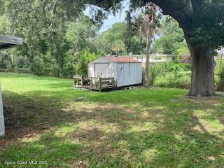 1055 Marlin Drive Rockledge, FL 32955 - Photo 14 of 14 a view of a backyard with large trees and a barn