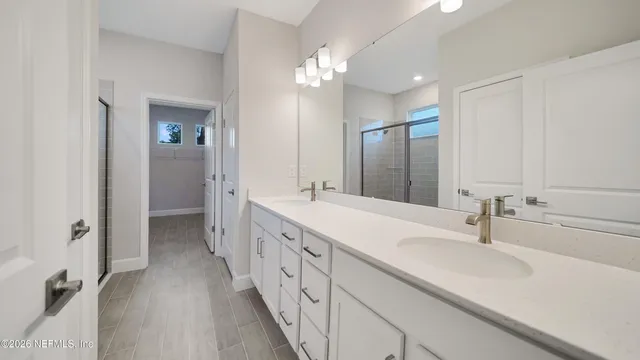 a bathroom with double vanity and a mirror