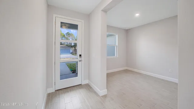 an empty room with mirror and windows