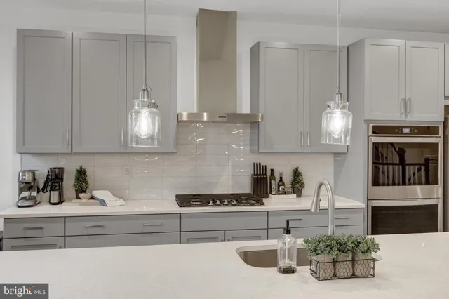 a large white kitchen with lots of counter space wooden floor and appliances