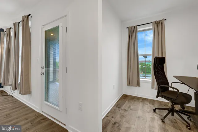 a view of a hallway with wooden floor and staircase