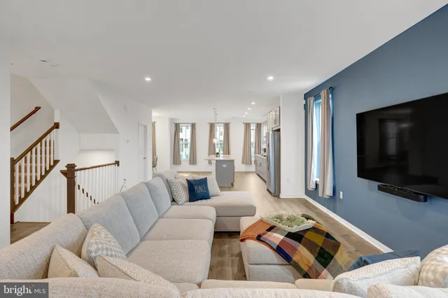 a large kitchen with kitchen island a large counter top stainless steel appliances and cabinets