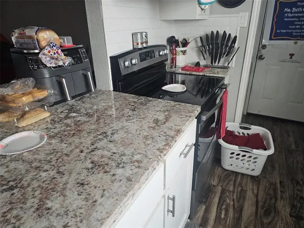a bathroom with a granite countertop sink a toilet and mirror