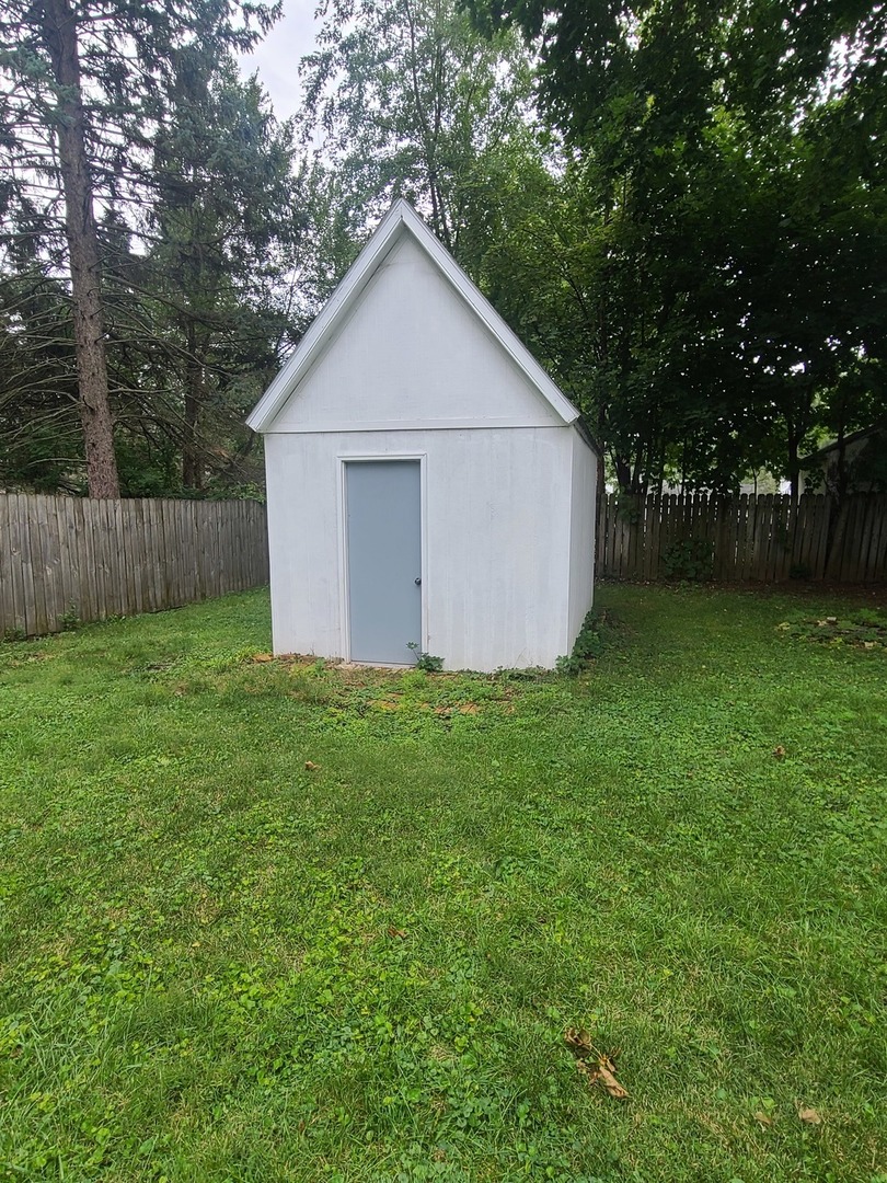 606 South 3rd Street Rochelle, IL 61068 - Photo 18 of 18 a view of a backyard with large trees and wooden fence