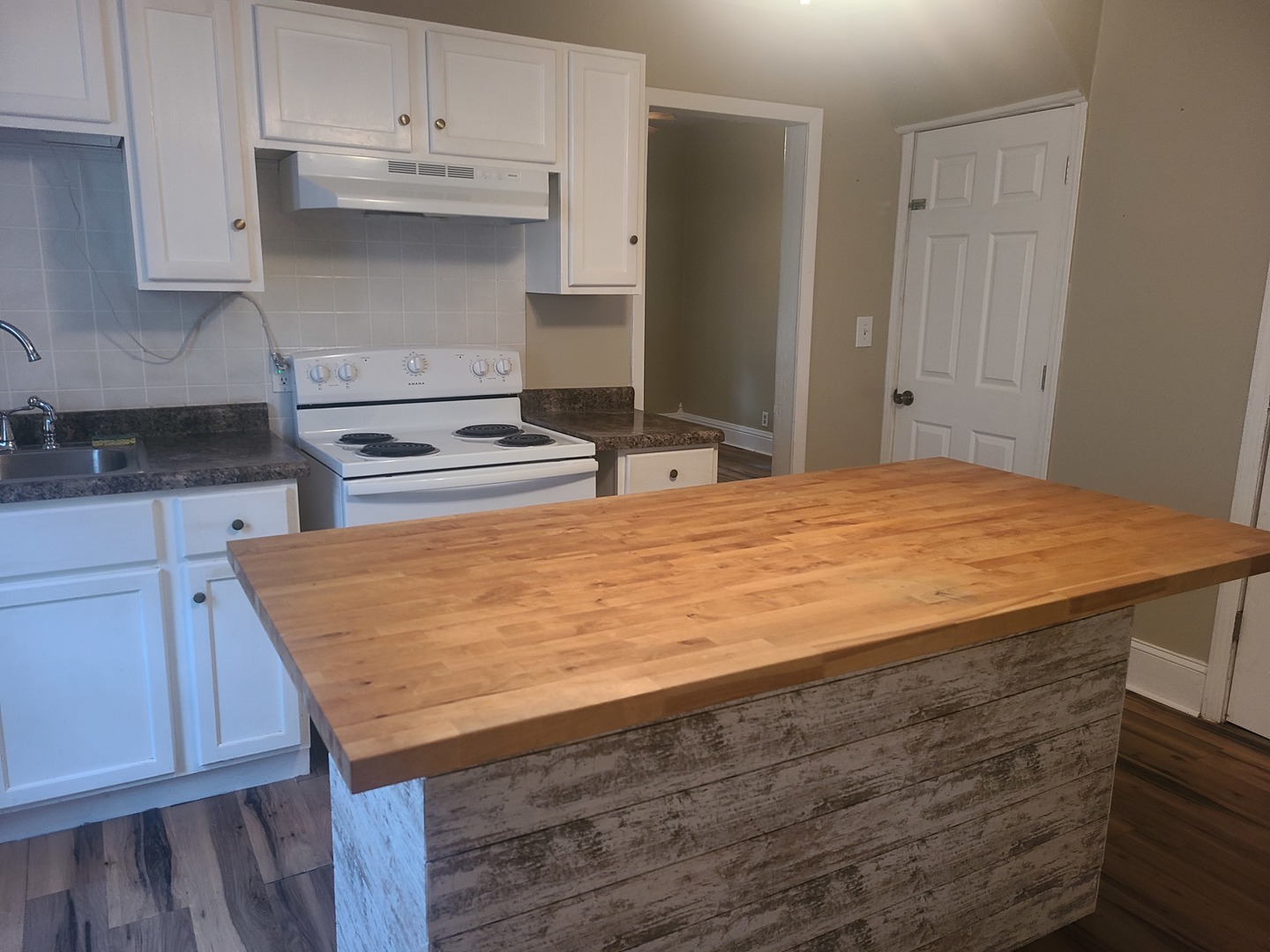 606 South 3rd Street Rochelle, IL 61068 - Photo 3 of 18 a room with kitchen island a sink a stove and cabinets