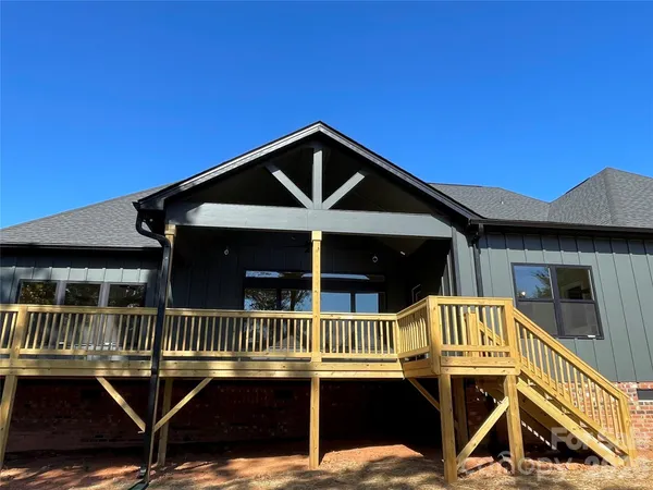 a view of a house with a deck and a yard