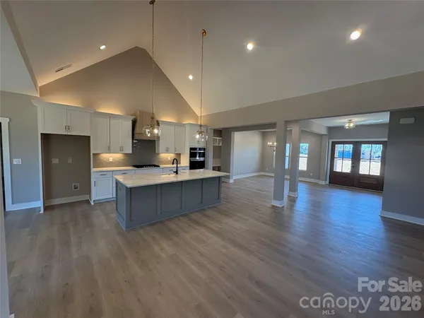 a large kitchen with stainless steel appliances granite countertop a large counter top a sink and a refrigerator
