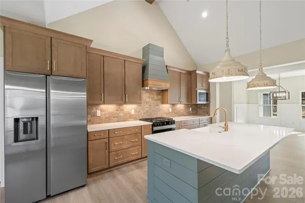a kitchen with a sink stainless steel appliances and white cabinets