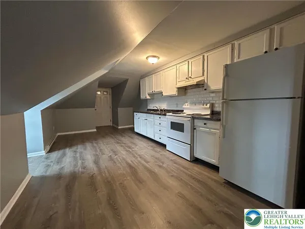 a kitchen with a refrigerator and a stove top oven
