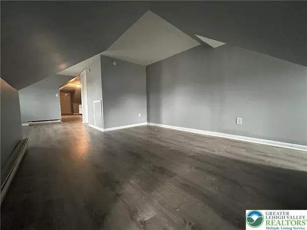 a view of an empty room with wooden floor