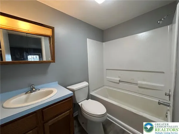 a bathroom with a sink vanity mirror and toilet