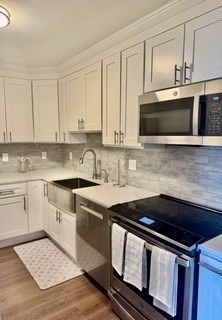 41 Park Brookline Ma, Unit 404 Brookline, MA 02446 - Photo 13 of 24 a kitchen with stainless steel appliances a stove a microwave sink and cabinets