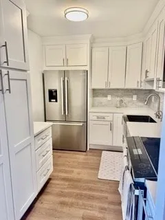 a kitchen with white cabinets and white appliances