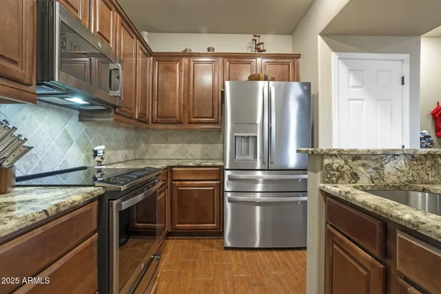 a kitchen with granite countertop stainless steel appliances and wooden cabinets
