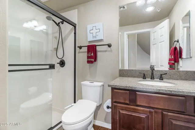a bathroom with a granite countertop sink toilet and shower