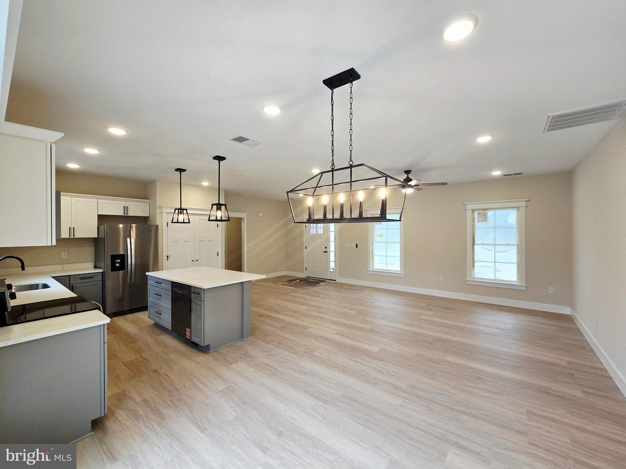 26707 Shortly Road Georgetown, DE 19947 - Photo 11 of 35 a kitchen with stainless steel appliances wooden floor dining table and chairs