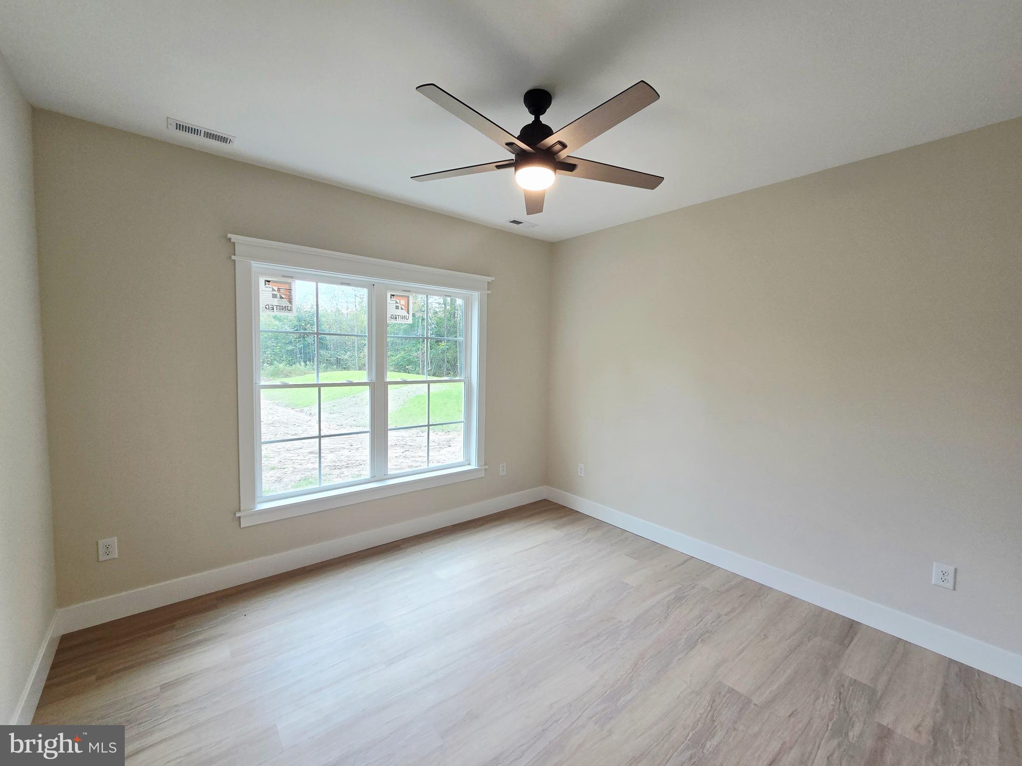 26707 Shortly Road Georgetown, DE 19947 - Photo 22 of 35 an empty room with wooden floor fan and windows