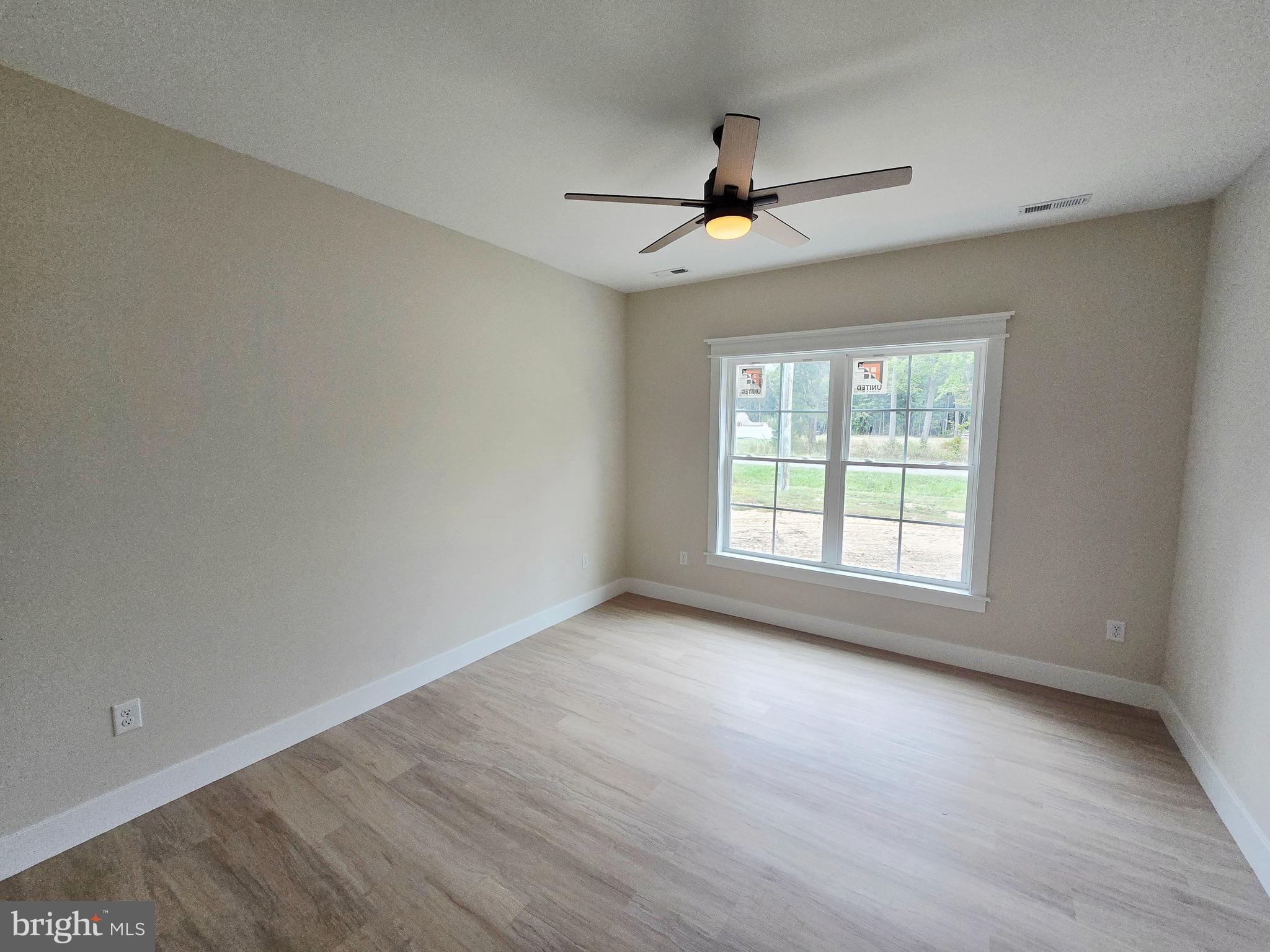 26707 Shortly Road Georgetown, DE 19947 - Photo 24 of 35 an empty room with wooden floor fan and windows