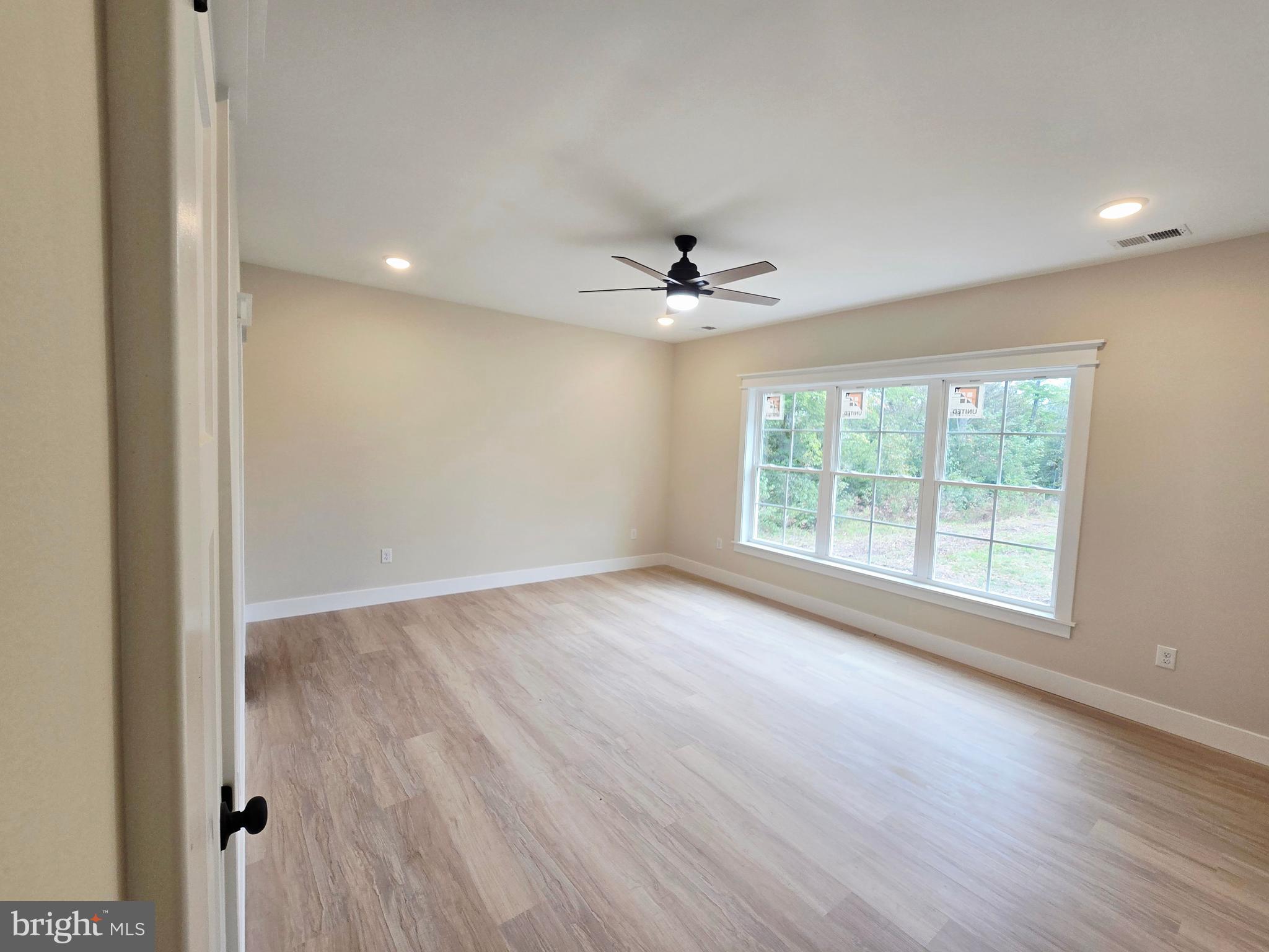 26707 Shortly Road Georgetown, DE 19947 - Photo 27 of 35 a view of an empty room with a window and wooden floor