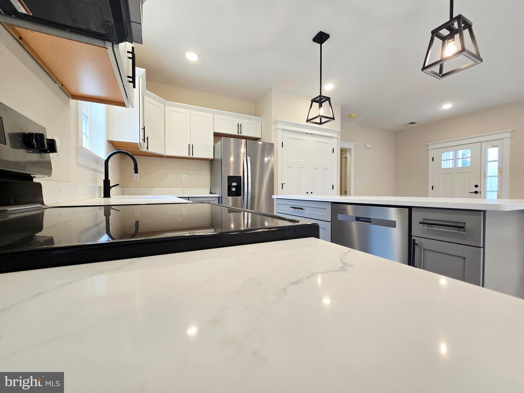 26707 Shortly Road Georgetown, DE 19947 - Photo 7 of 35 a kitchen with stainless steel appliances a sink dishwasher a stove top oven a dining table and chairs with wooden floor