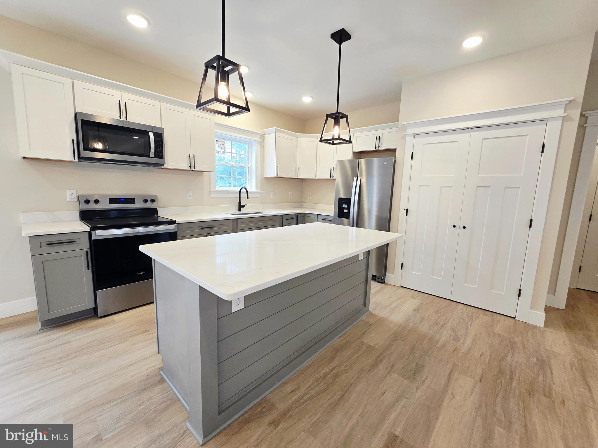 26707 Shortly Road Georgetown, DE 19947 - Photo 8 of 35 a kitchen with stainless steel appliances kitchen island granite countertop a sink a stove and a wooden floors
