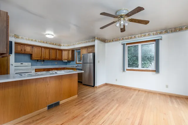 a kitchen with stainless steel appliances granite countertop a stove cabinets and wooden floor
