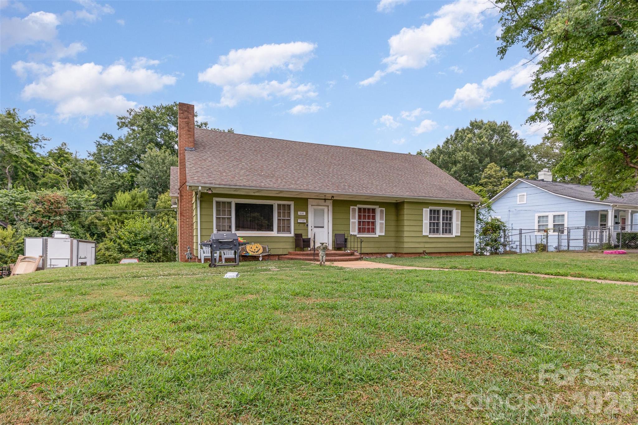 1318 Enderly Road, Unit 1B Charlotte, NC 28208 - Photo 3 of 5 a front view of a house with a garden and trees