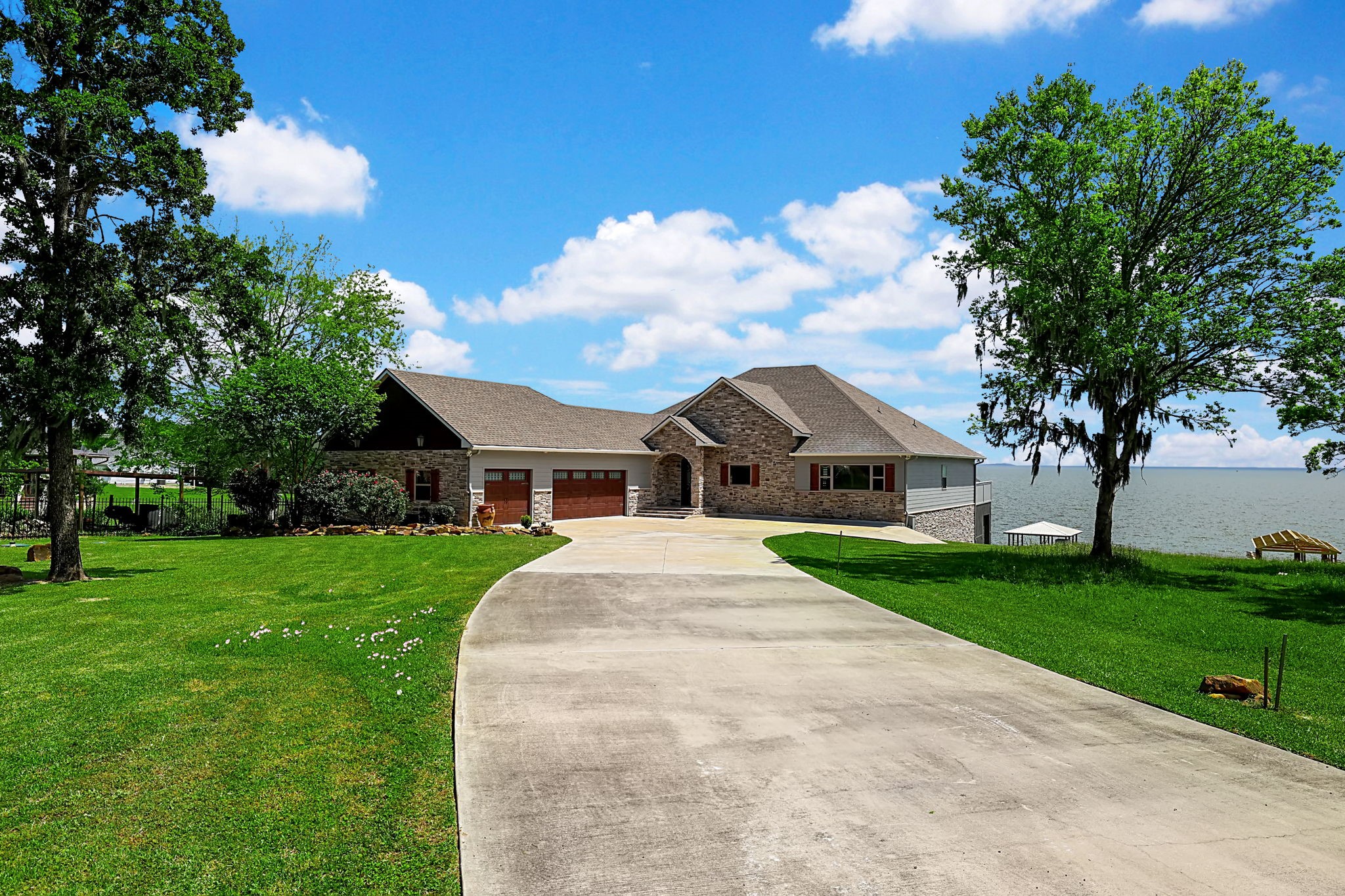 260 Legacy Blvd Point Point Blank, TX 77364 - Photo 3 of 46 Set on the open water with three car attached garage and plenty of driveway parking for guests