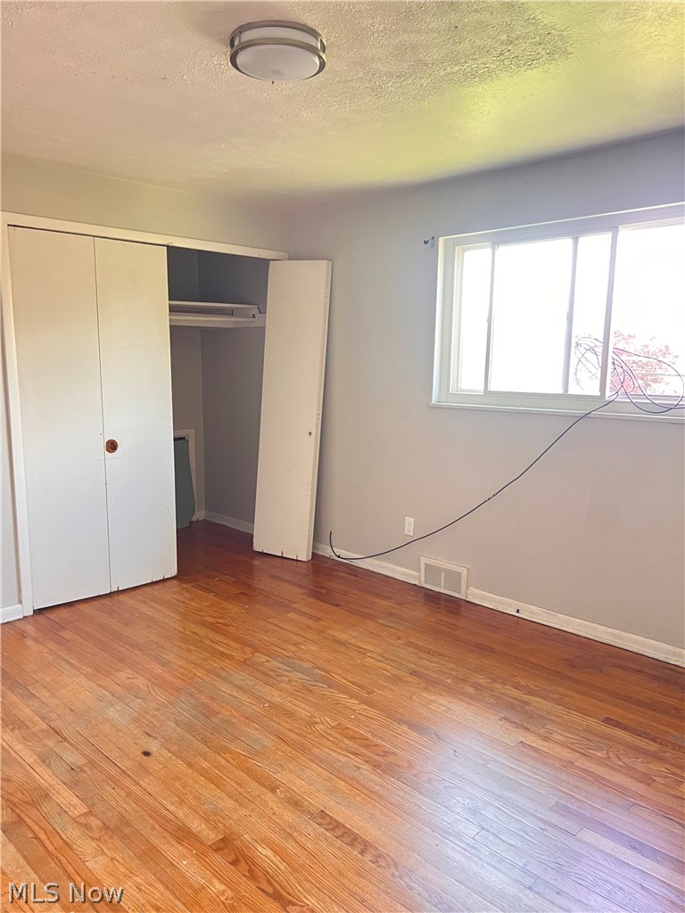 16350 Rockside Road Maple Heights, OH 44137 - Photo 27 of 34 Room featuring wood flooring, neutral tone walls, and a large window