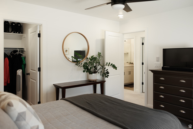 629 Spring Lily Drive St. George, UT 84790 - Photo 27 of 50 Bedroom featuring a ceiling fan with integrated lighting, a closet with shelving and hanging space, and an en-suite bathroom entry with vanity visible