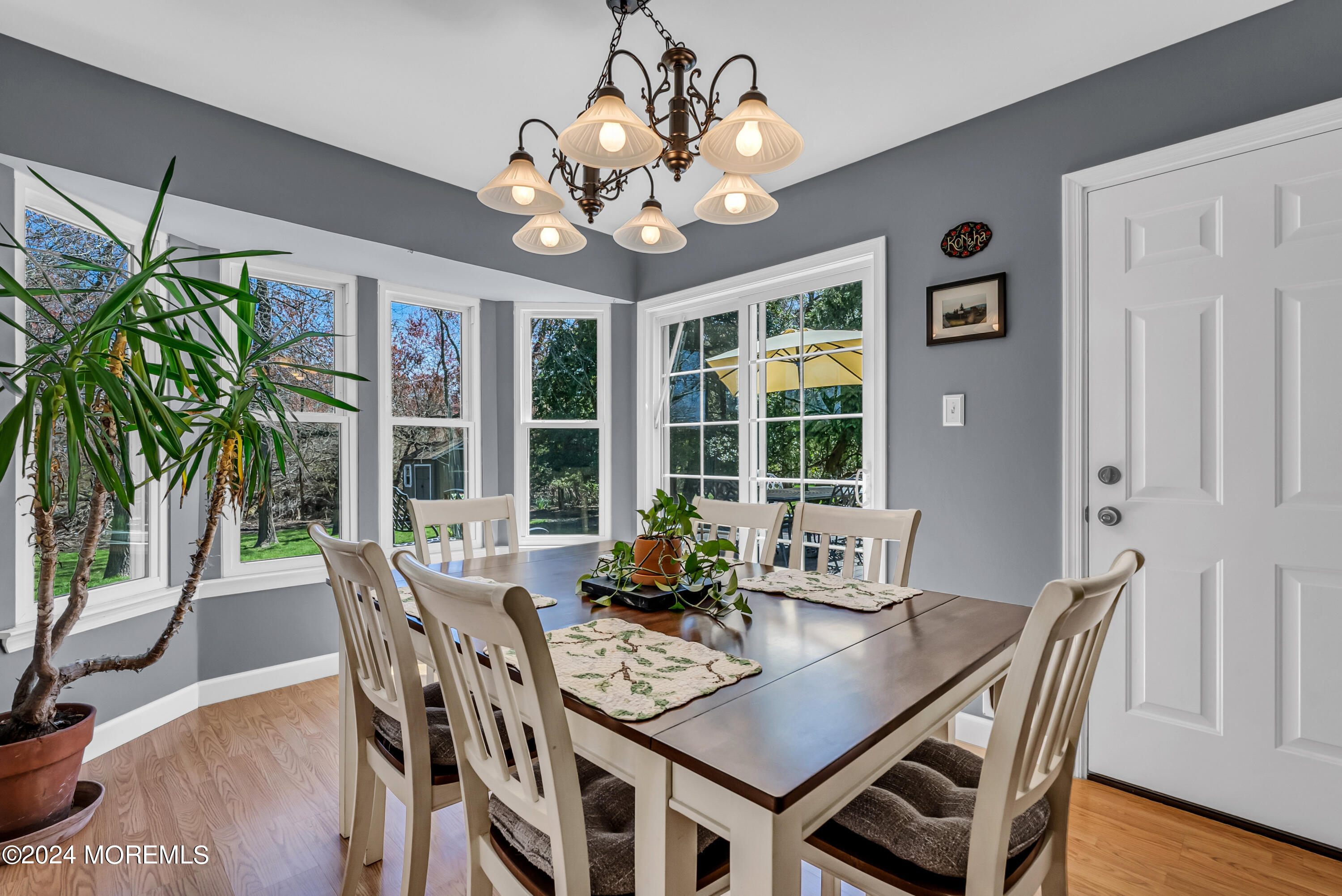22 Oak Glen Road Toms River, NJ 08753 - Photo 5 of 25 a dining room with wooden floor a chandelier a wooden table and chairs