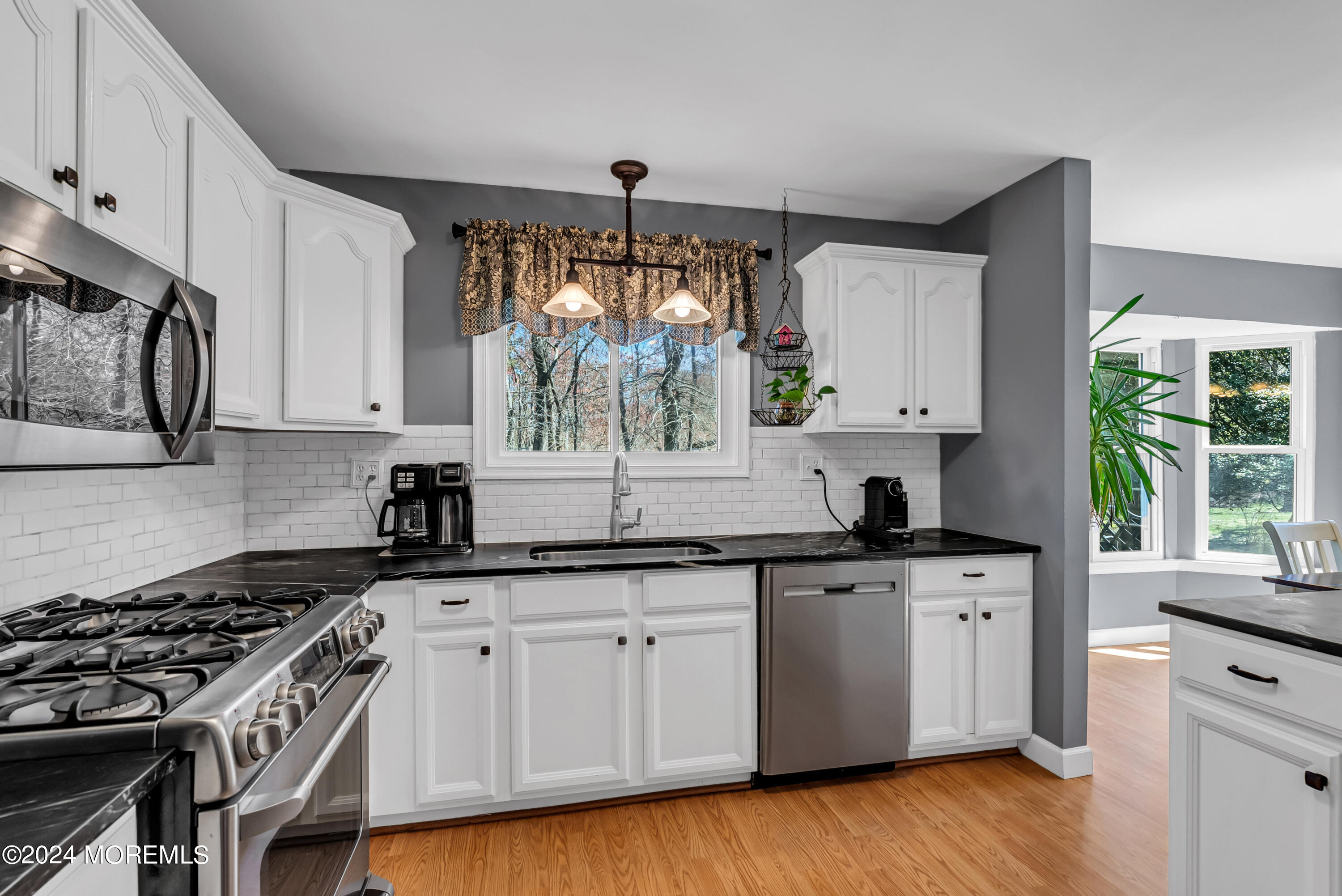 22 Oak Glen Road Toms River, NJ 08753 - Photo 6 of 25 a kitchen with granite countertop a sink cabinets wooden floor and stainless steel appliances