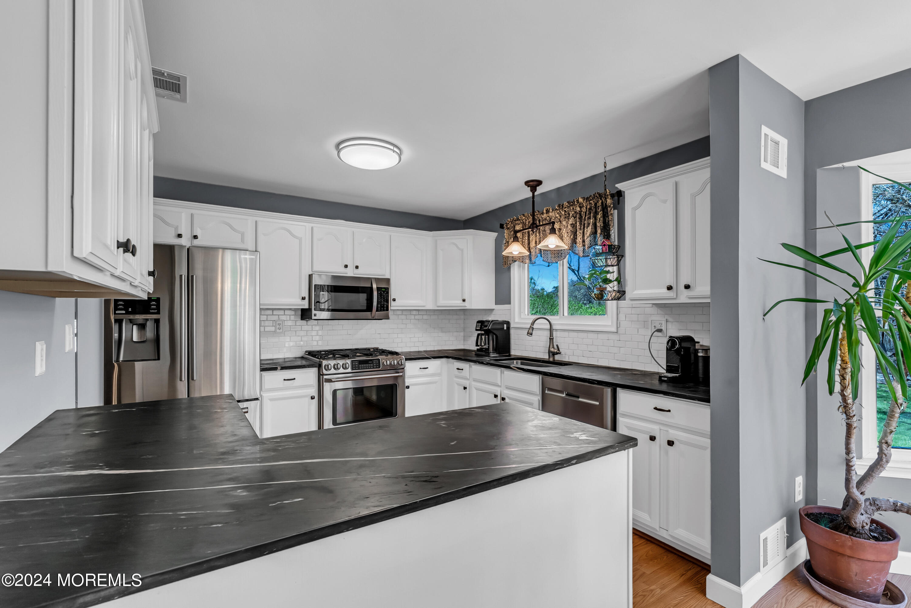 22 Oak Glen Road Toms River, NJ 08753 - Photo 7 of 25 a kitchen with granite countertop a stove a sink and a microwave