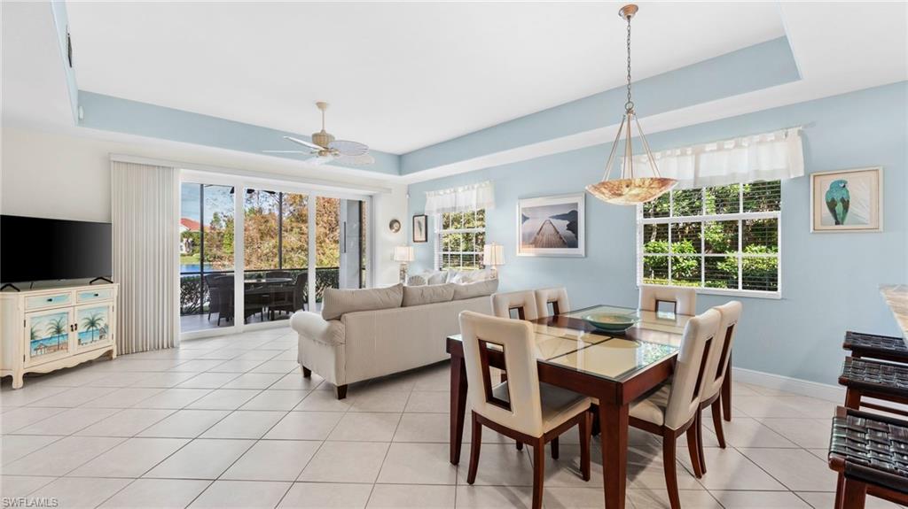 7876 Hawthorne Drive, Unit 1202 Naples, FL 34113 - Photo 9 of 48 Dining space featuring ceiling fan, a raised ceiling, and light tile patterned floors