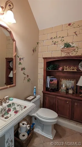 a bathroom with a toilet a sink and view kitchen