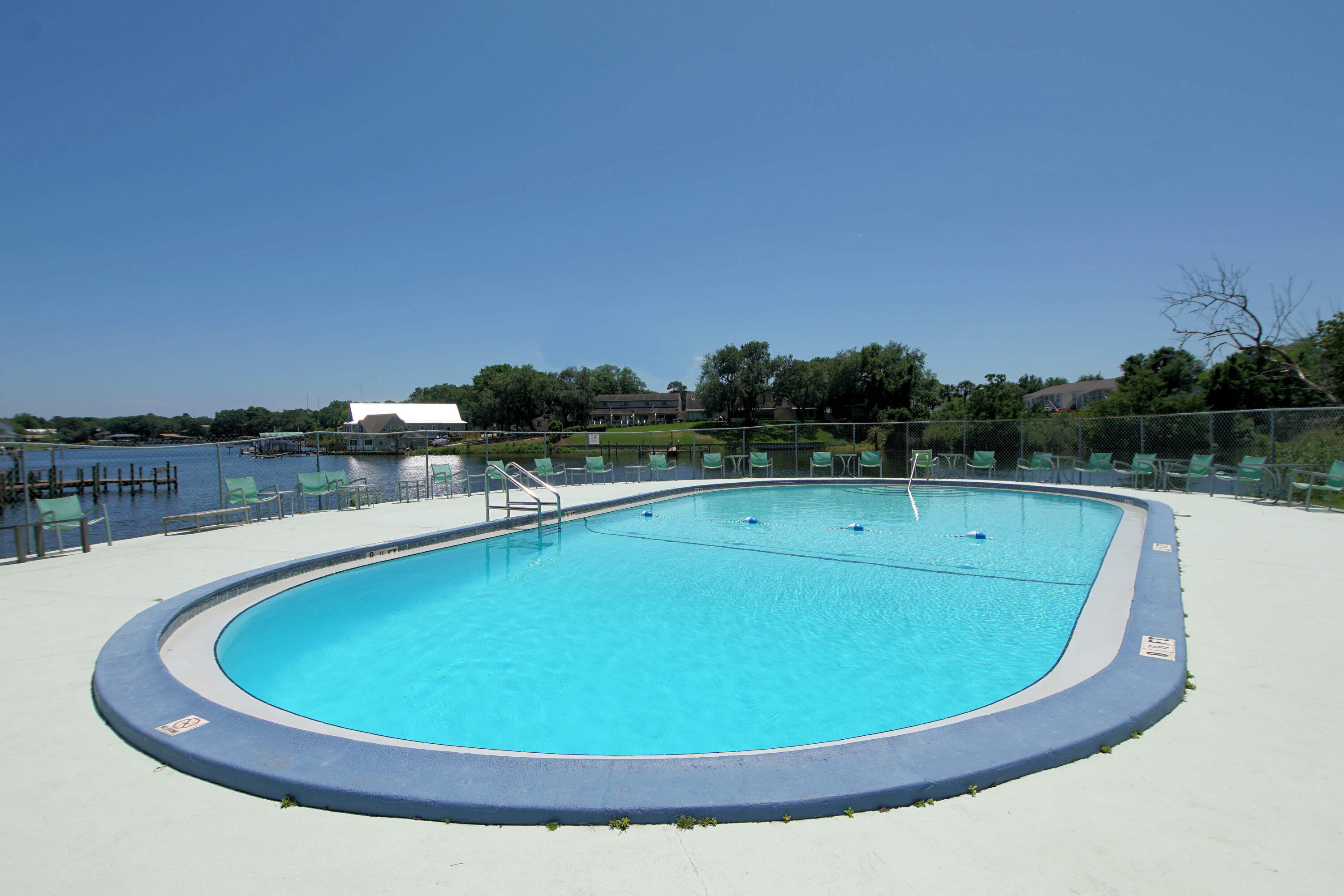 210 Pelham Road, Unit 219C Fort Walton Beach, FL 32547 - Photo 21 of 23 a view of a swimming pool with lake and mountain in the back